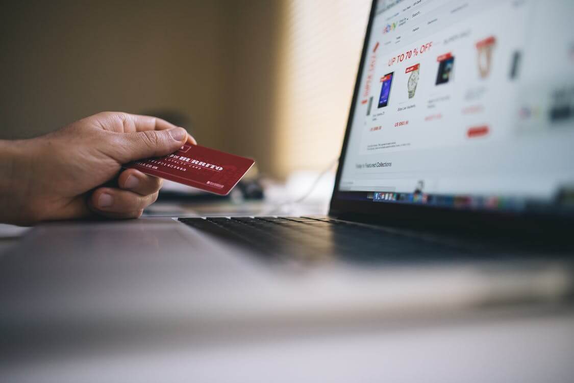 Consommateur devant son ordinateur avec une carte de crédit